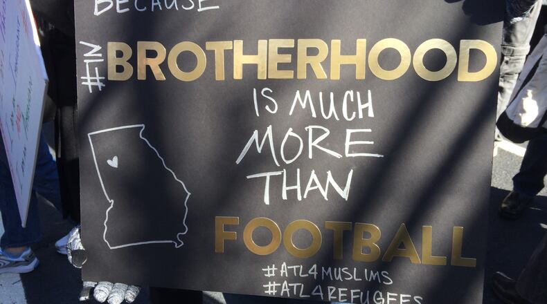 One of the signs at Saturday’s “Atlanta Stands with Muslims & Refugees ” rally was a nod to the Atlanta Falcons’ signature slogan. Photo by Jill Vejnoska jvejnoska@ajc.com