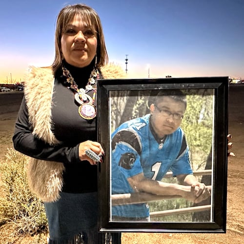Vangie Randall-Shorty holds up a photograph of her son Zachariah Shorty during a stop in Bernalillo, N.M., Nov. 24, 2025. (AP Photo/Susan Montoya Bryan)