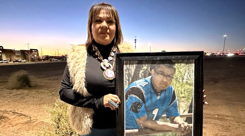 Vangie Randall-Shorty holds up a photograph of her son Zachariah Shorty during a stop in Bernalillo, N.M., Nov. 24, 2025. (AP Photo/Susan Montoya Bryan)