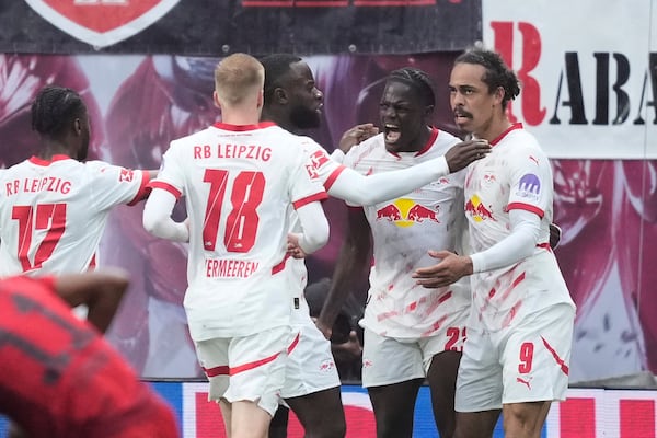 Leipzig's Yussuf Poulsen, right, celebrates with teammates after scoring his side's third goal during the German Bundesliga soccer match between RB Leipzig and FC Bayern Munich at the Red Bull Arena in Leipzig, Germany, Saturday, May 3, 2025. (AP Photo/Ebrahim Noroozi)