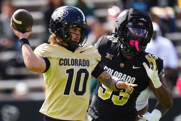 Colorado quarterback Julian Lewis (10) throws under pressure from defensive end Arden Walker (53) during Colorado's NCAA college football spring game, Saturday, April 19, 2025, in Boulder, Colo. (AP Photo/Jack Dempsey)