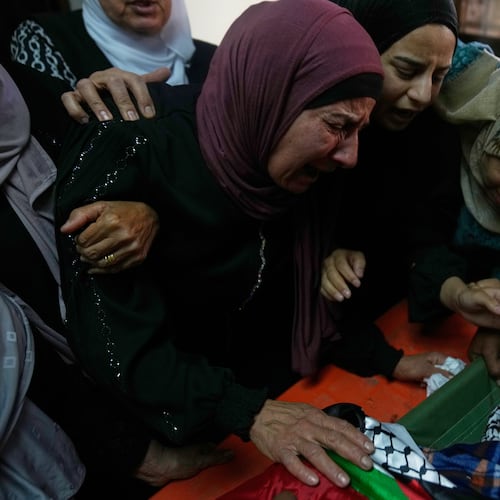 Wafa Hammad, 52, left, mother of Palestinian teen Yamen Hamed, 15 who was allegedly killed by the Israeli army during overnight clashes, cries while she takes the last look at his body during his funeral in the West Bank town of Silwad Friday, Oct. 31, 2025. (AP Photo/Nasser Nasser)