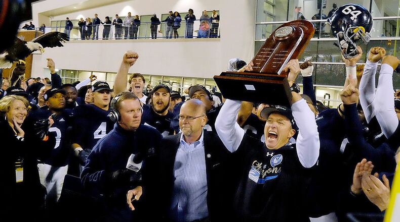 Georgia Southern head coach Willie Fritz hoists the Sun Belt Conference trophy after his team defeated the Louisiana Monroe Warhawks on Nov. 29, 2014, at Paulson Stadium in Statesboro, Ga. The Eagles went 8-0 in their inaugural year in the Sun Belt Conference.