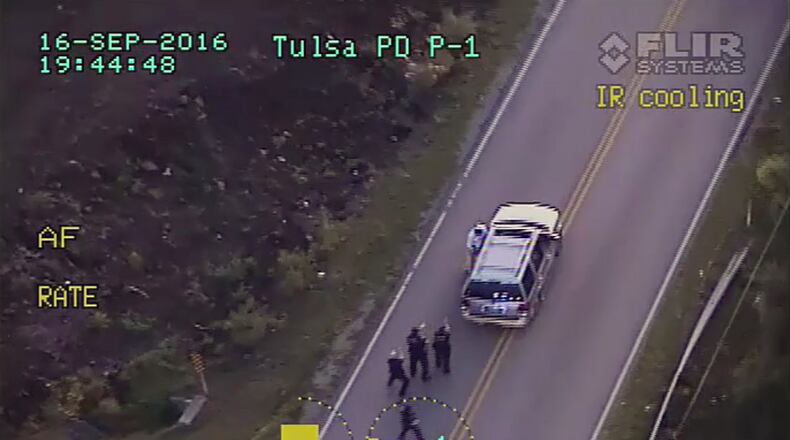 In this image made from a Friday, Sept. 16, 2016 police video, Terence Crutcher, top, is pursued by police officers as he walk to an SUV in Tulsa, Okla. Crutcher was taken to the hospital where he was pronounced dead after he was shot by the officer around 8 p.m., Friday, police said. Crutcher had no weapon on him or in his SUV, Tulsa Police Chief Chuck Jordan said Monday, Sept. 19, 2016. (Tulsa Police Department via AP)