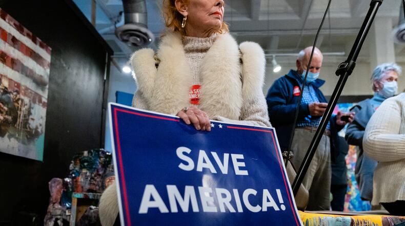 Teresa Gipson, of Atlanta, holds a 'Save America' sign during a stop on the 'Save America’ statewide bus tour organized by The Club For Growth, on Wednesday, December 16, 2020, in Atlanta. (Elijah Nouvelage for The Atlanta Journal-Constitution)