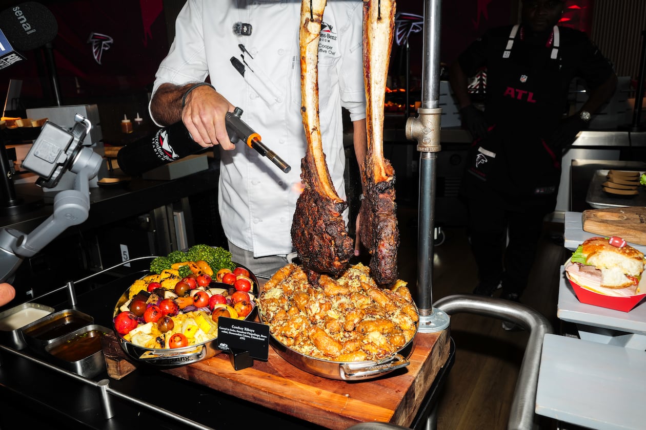 Senior executive chef Matt Cooper torches a steak at a media event showcasing new food and beverage options at Mercedes-Benz Stadium in Atlanta on Tuesday, Sept. 15, 2026, ahead of the Falcons home opener. (Arvin Temkar/AJC)