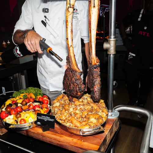 Senior executive chef Matt Cooper torches a steak at a media event showcasing new food and beverage options at Mercedes-Benz Stadium in Atlanta on Sept. 15, 2026, ahead of the Falcons home opener. (Arvin Temkar/AJC)