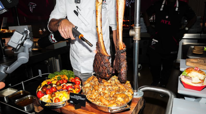 Senior executive chef Matt Cooper torches a steak at a media event showcasing new food and beverage options at Mercedes-Benz Stadium in Atlanta on Tuesday, Sept. 15, 2026, ahead of the Falcons home opener. (Arvin Temkar/AJC)