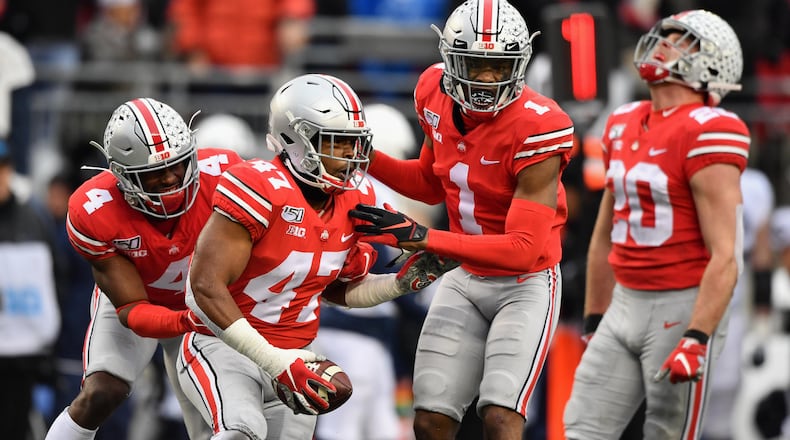 COLUMBUS, OH - NOVEMBER 23:  Justin Hilliard #47 of the Ohio State Buckeyes celebrates with teammates /bbd4 #4 and Jeff Okudah #1 after intercepting a Penn State Nittany Lions pass in the fourth quarter at Ohio Stadium on November 23, 2019 in Columbus, Ohio. Ohio State defeated Penn State 28-17.  (Photo by Jamie Sabau/Getty Images)