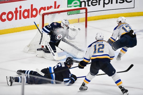 St. Louis Blues' Radek Faksa (12) scores against Winnipeg Jets goaltender Connor Hellebuyck (37) during the second period of Game 7 in an NHL hockey first-round playoff series in Winnipeg, Manitoba, Sunday, May 4, 2025. (Fred Greenslade/The Canadian Press via AP)