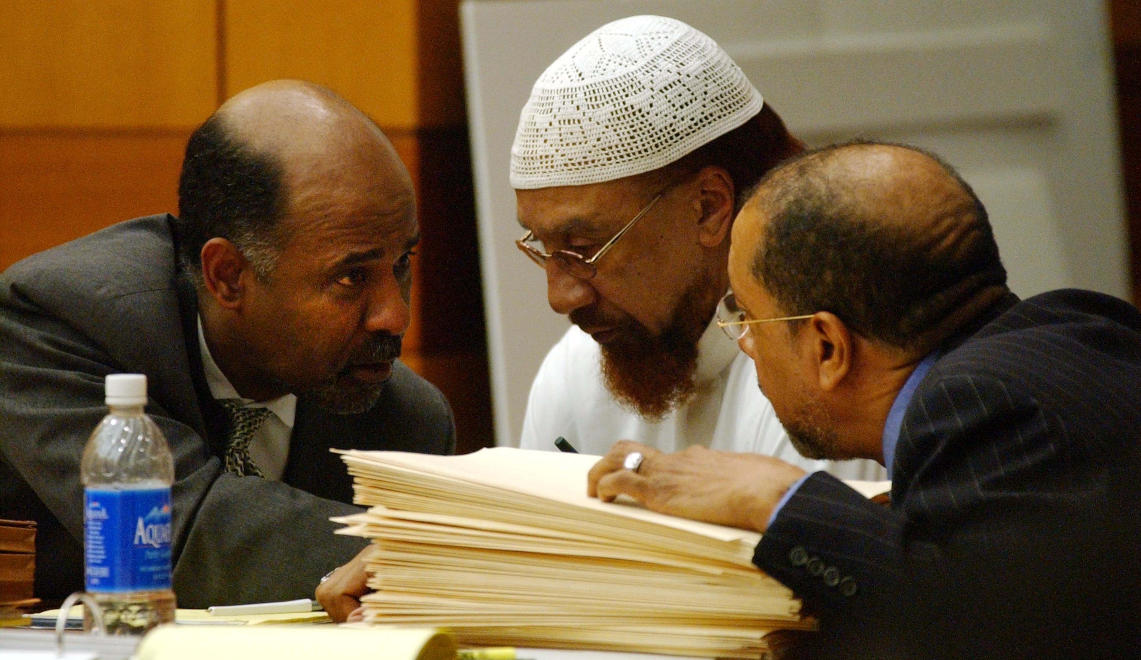 Defense lawyer Tony Axam (on left), defendant Jamil Abdullah Al-Amin, and defense lawyer Michael Warner confer during the first day of Al-Amin's trial in Fulton Superior Court in downtown Atlanta Tuesday, February 19, 2002. Al-Amin was charged with the shooting death of Fulton County Sheriff Deputy Richard Kinchen, when Kinchen and partner Aldranon English attempted to serve Al-Amin with a warrant. English was also shot & wounded in the attack. (Bita Honarvar/AJC)