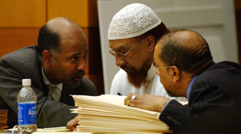 Defense lawyer Tony Axam (on left), defendant Jamil Abdullah Al-Amin, and defense lawyer Michael Warner confer during the first day of Al-Amin's trial in Fulton Superior Court .