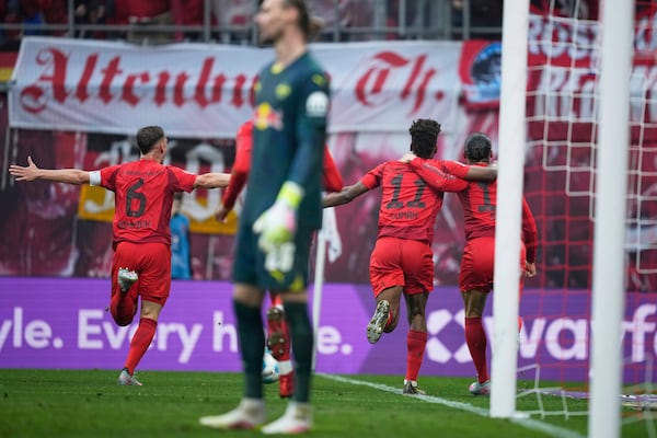 Bayern's Leroy Sane, right, celebrates with teammates after scoring his side's third goal during the German Bundesliga soccer match between RB Leipzig and FC Bayern Munich at the Red Bull Arena in Leipzig, Germany, Saturday, May 3, 2025. (AP Photo/Ebrahim Noroozi)
