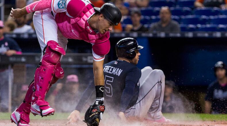 Atlanta Braves first baseman Freddie Freeman slides safely into home plate to score as Miami Marlins catcher J.T. Realmuto misses the tag during the first inning on Sunday, May 13, 2018, in Miami, Fla. (Daniel A.Varela/Miami Herald/TNS)