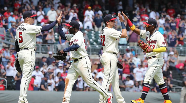 Braves players Freddie Freeman (from left), Guillermo Heredia, Austin Riley and Ronald Acuna celebrate a 7-1 victory over the Pittsburgh Pirates Sunday, May 23, 2021, at Truist Park in Atlanta. (Curtis Compton / Curtis.Compton@ajc.com)