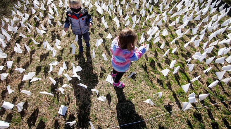 Francis Drenner (left) and his twin sister, Margaret, plant some of the 15,000 flags on the lawn of First Christian Church of Decatur on Saturday. (Photo: Steve Schaefer for The Atlanta Journal-Constitution)
