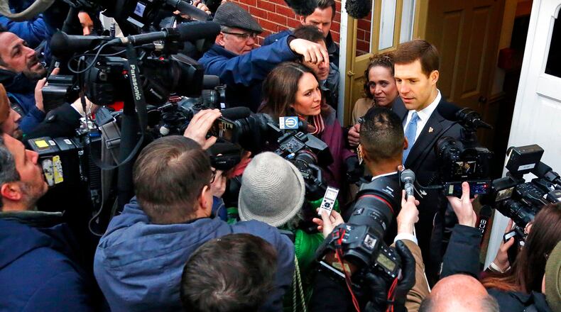 Conor Lamb, the Democratic candidate for the special election in Pennsylvania's 18th Congressional District, right, is surrounded by media after voting in Mount Lebanon, Pa., Tuesday, March 13, 2018. Lamb is running against Republican Rick Saccone. (AP Photo/Gene J. Puskar)