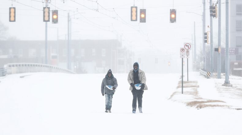 Jimmy Jordan, left, and Cordarol Dale walk through snow in Memphis, Tenn., Saturday, Jan. 24, 2026. (Mark Weber/Daily Memphian via AP)