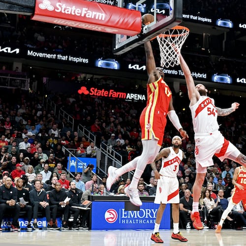Atlanta Hawks forward/center Onyeka Okongwu (17) dunks the ball against Toronto Raptors forward/center Sandro Mamukelashvili (54) during the second half in the home opener at State Farm Arena, Thursday, October 22, 2025, in Atlanta. Toronto Raptors won 138-118 over Atlanta Hawks. (Hyosub Shin / AJC)