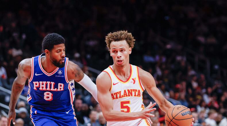 Atlanta Hawks guard Dyson Daniels (5) dribbles against Philadelphia 76ers forward Paul George (8) during the first half at State Farm Arena during an NBA exhibition game on Monday, October 14, 2024, in Atlanta. (Miguel Martinez/ AJC)