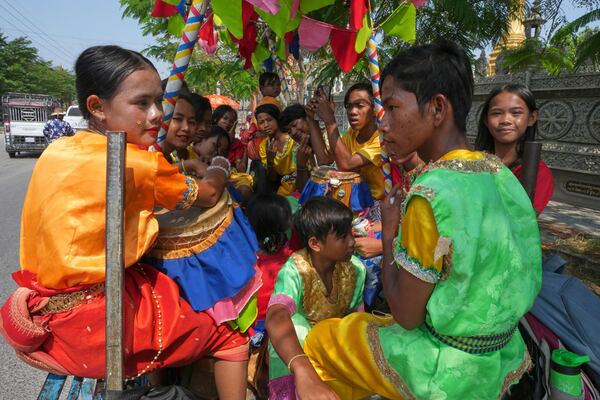 Local blessing dancers sit on a motor-cart as they head to dance through the villages to celebrate the traditional New Year holiday at the outskirts of Phnom Penh Cambodia, Sunday, April 13. 2025. People celebrate the traditional New Year holiday between April 14-16.(AP Photo/Heng Sinith)