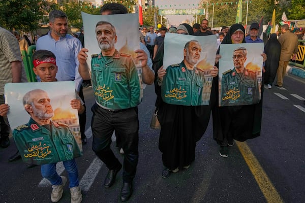 Demonstrators carry posters of top Iranian commanders killed in Friday's Israeli strikes on Tehran, during the Muslim Shiite holiday of Eid al-Ghadir, which commemorates the Prophet Muhammad naming Ali, revered as the first Shiite imam, as his successor, in Tehran, Iran, Saturday, June 14, 2025. (AP Photo/Vahid Salemi)