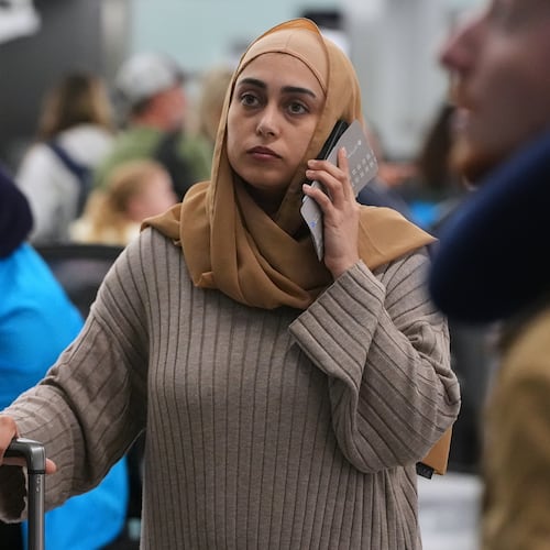 A traveler checks the status of her flight at the O'Hare International Airport in Chicago, Sunday, Nov. 30, 2025. (AP Photo/Nam Y. Huh)