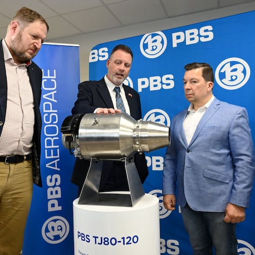 Erin Durham (second from left), CEO of PBS Aerospace, shows a PBS subsonic engine to (from left) David Müller, deputy minister of the Czech Ministry of Industry and Trade; Miloslav Stašek, Czech ambassador to the U.S.; and Jakub Fischer, managing director of PBS Aerospace on May 14, 2026, in Roswell. (Hyosub Shin/AJC)