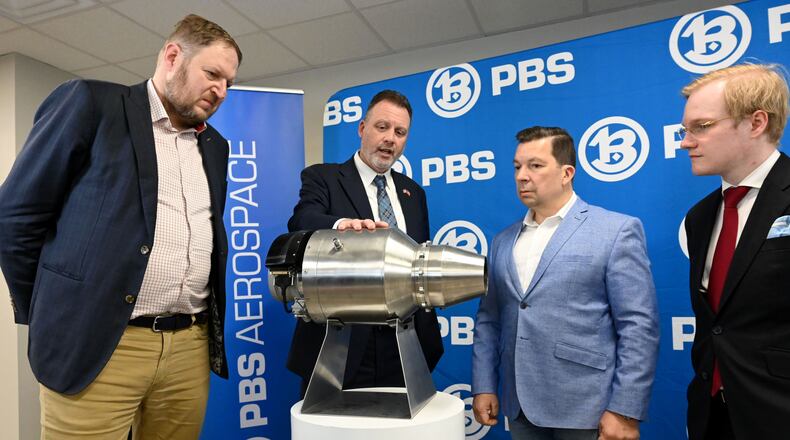 Erin Durham (second from left), CEO of PBS Aerospace, shows a PBS subsonic engine to (from left) David Müller, deputy minister of the Czech Ministry of Industry and Trade; Miloslav Stašek, Czech ambassador to the U.S.; and Jakub Fischer, managing director of PBS Aerospace on May 14, 2026, in Roswell. (Hyosub Shin/AJC)