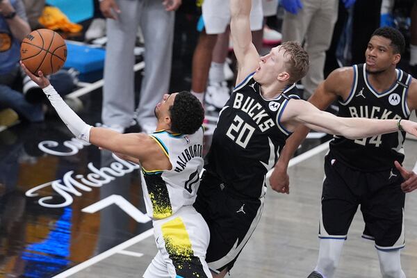 Milwaukee Bucks guard AJ Green (20) fouls Indiana Pacers guard Tyrese Haliburton (0) as he shoots during overtime in Game 5 of an NBA basketball first-round playoff series in Indianapolis, Tuesday, April 29, 2025. (AP Photo/Michael Conroy)