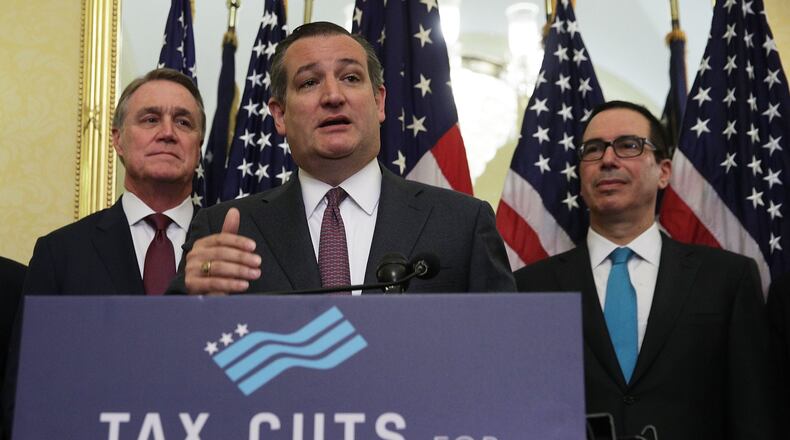 WASHINGTON: U.S. Sen. Ted Cruz, R-Texas, speaks as U.S. Sen. David Perdue, R-Georgia, (left) and Secretary of the Treasury Steven Mnuchin listen during a news conference on tax reform Tuesday on Capitol Hill. Senate Republicans held a news conference to discuss tax reform and its impact on American families, small businesses and the economy. ALEX WONG/GETTY IMAGES.