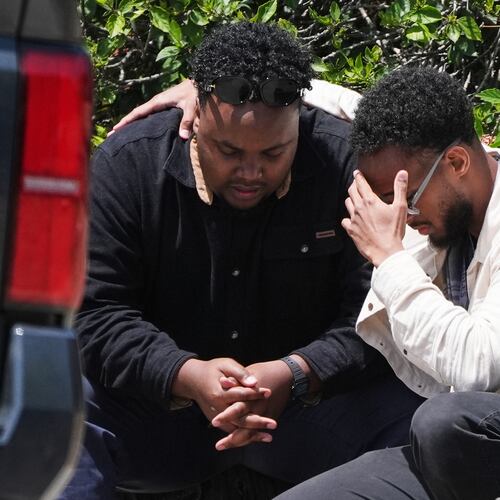 Two men embrace at the scene of a shooting outside the Islamic Center of San Diego Monday, May 18, 2026, in San Diego. (AP Photo/Gregory Bull)