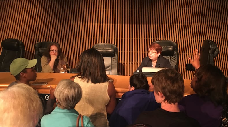 Gwinnett County Commission Chairman Charlotte Nash (center right) and Commissioner Lynette Howard (left) address a group of "racist pig" protesters after Tuesday night's board meeting.