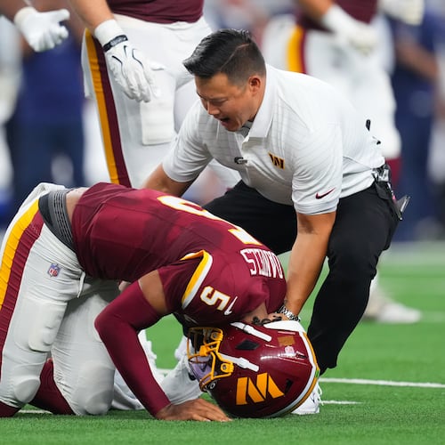 Washington Commanders quarterback Jayden Daniels (5) reacts after an apparent injury in the first half against the Dallas Cowboys during an NFL football game in Arlington, Texas, Sunday, Sept. 20, 2026. (AP Photo/Julio Cortez)