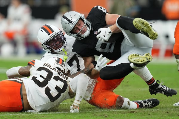 Cleveland Browns safety Ronnie Hickman (33) and Cleveland Browns cornerback Tyson Campbell (7) tackle Las Vegas Raiders tight end Brock Bowers (89) during the first half of an NFL football game Sunday, Nov. 23, 2025, in Las Vegas. (AP Photo/Candice Ward)