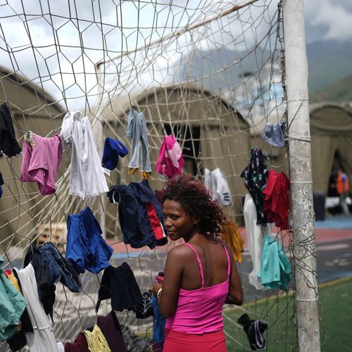 Nataly Mayora hangs clothes to dry on a soccer goal net as she does laundry at a sports center sheltering people displaced by the earthquakes in La Guaira, Venezuela, Thursday, July 9, 2026. (AP Photo/Ariana Cubillos)