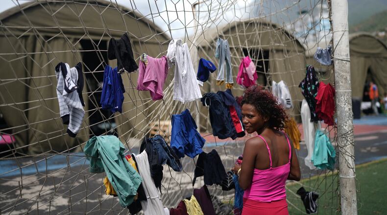 Nataly Mayora hangs clothes to dry on a soccer goal net as she does laundry at a sports center sheltering people displaced by the earthquakes in La Guaira, Venezuela, Thursday, July 9, 2026. (AP Photo/Ariana Cubillos)