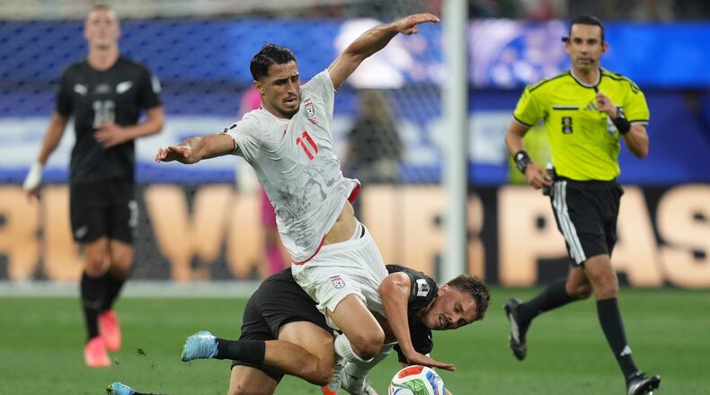 Iran's Ali Alipour (11) battles for the ball with New Zealand's Ryan Thomas (23) during the World Cup Group G soccer match between Iran and New Zealand in Inglewood, Calif., near Los Angeles, Monday, June 15, 2026. (AP Photo/Andre Penner)
