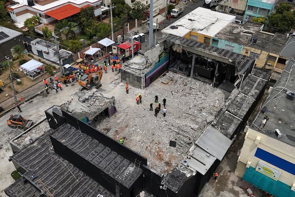 Rescue workers stand at the Jet Set nightclub days after its roof collapsed, killing more than 200 people in Santo Domingo, Dominican Republic, Thursday, April 10, 2025. (AP Photo/Matias Delacroix)