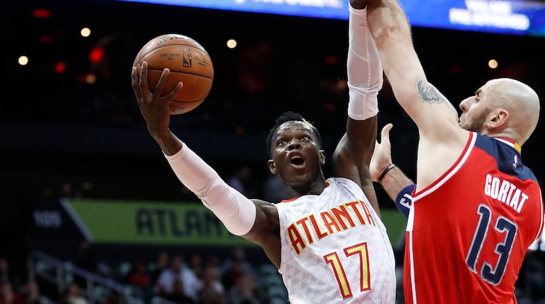 Atlanta Hawks guard Dennis Schroder (17) goes up for a shot against Washington Wizards center Marcin Gortat (13) in the first half of an NBA basketball game Friday, Jan. 27, 2017, in Atlanta. (AP Photo/John Bazemore)
