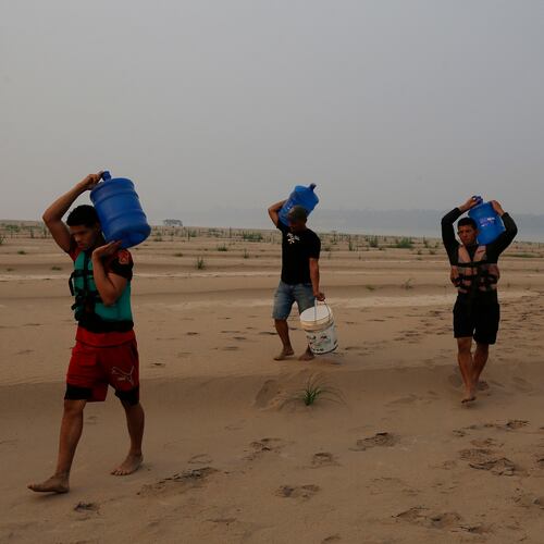 FILE - Residents transport drinking water from Humaita to the Paraizinho community, along a dry part of the Madeira River, a tributary of the Amazon River, amid a drought, Amazonas state, Brazil, Sep. 8, 2024. (AP Photo/Edmar Barros, File)