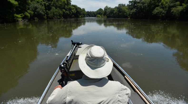 Glenn Cox, a fifth-generation farmer, guides his boat up the Flint River.