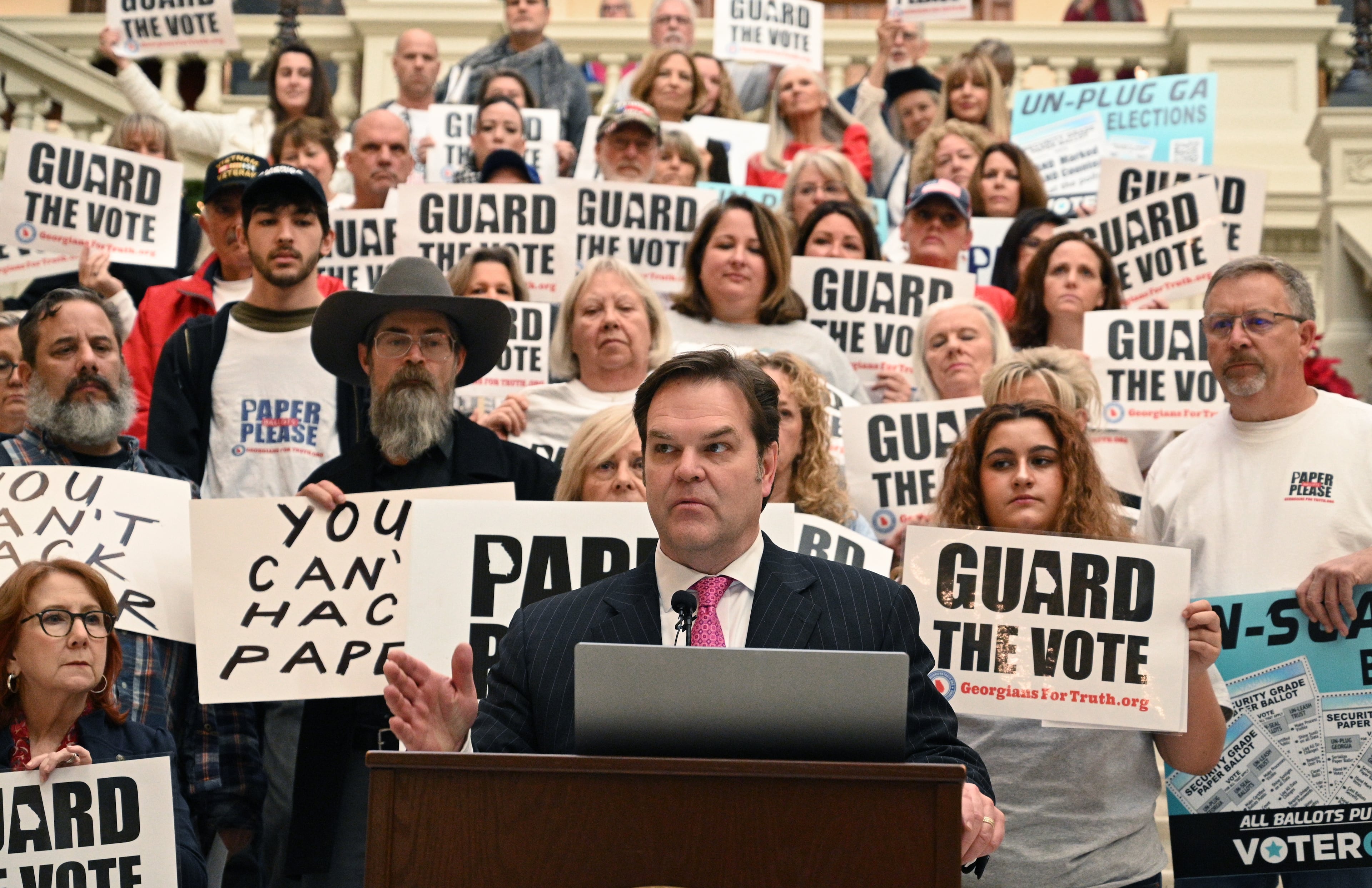 Attorney David Cross spoke at a news conference outside a State Election Board meeting in 2023 surrounded by supporters of paper ballots.