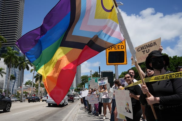 A person waves a rainbow flag during a protest against the Trump administration, Saturday, April 19, 2025, in Miami. (AP Photo/Lynne Sladky)