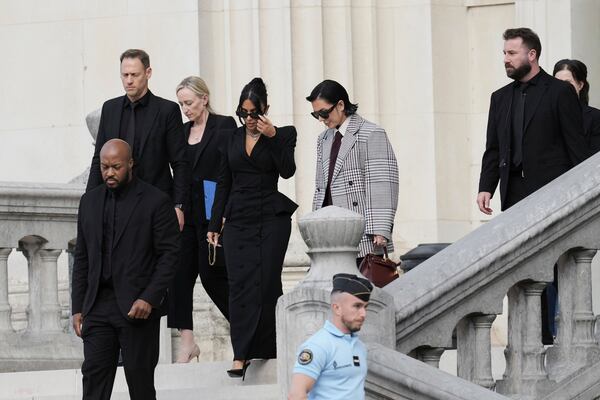 Kim Kardashian, center left, accompanied by her mother Kris Jenner, center right, leaves the justice palace after testifying, regarding a robbery of millions of dollars in jewels from her Paris hotel room in 2016, in Paris, Tuesday, May 13, 2025. (AP Photo/Aurelien Morissard)