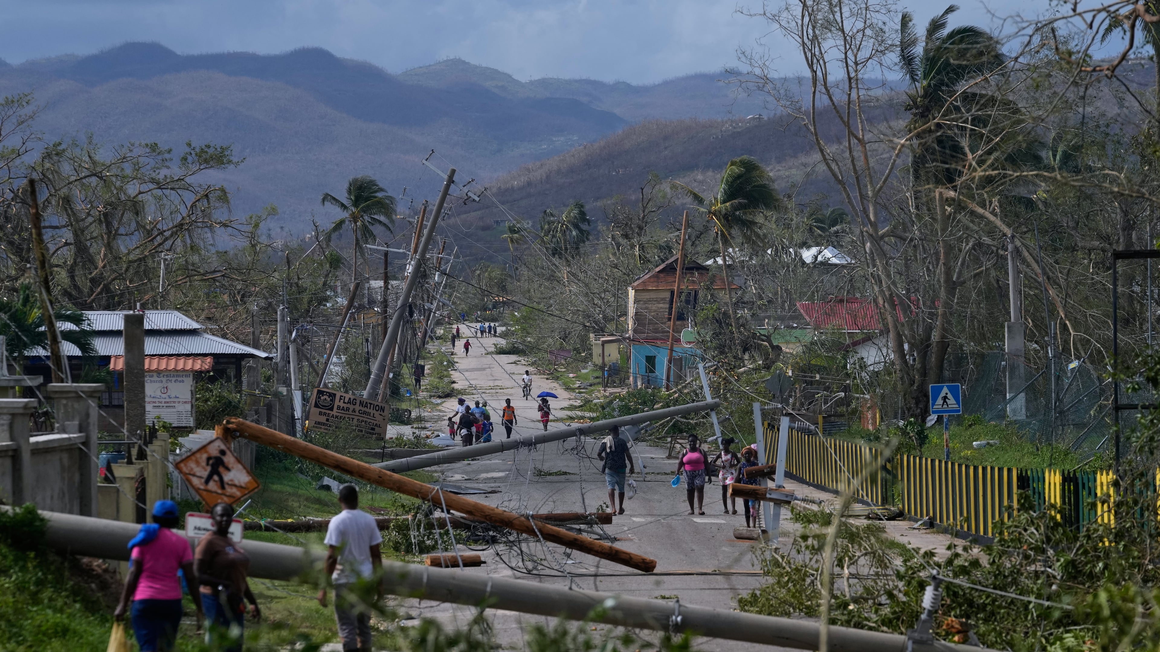 FILE - Residents walk through Lacovia Tombstone, Jamaica, in the aftermath of Hurricane Melissa, Wednesday, Oct. 29, 2025. (AP Photo/Matias Delacroix, File)