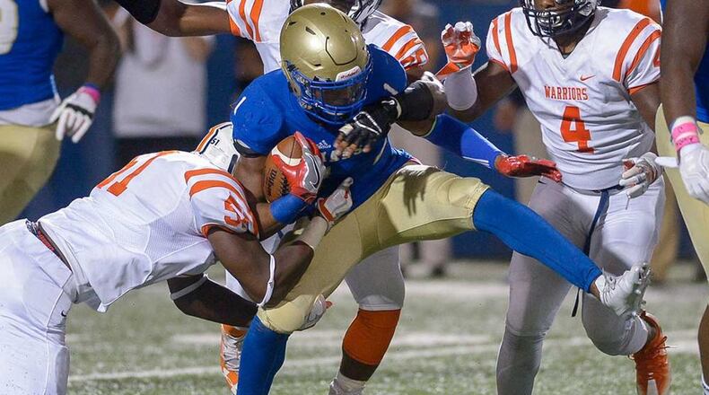 McEachern senior RB Quay Holmes (1) is brought down by North Cobb's Christian Albright (51), Michael Dixon (60) and Jai Erwin (4) in the first half of Friday's game. Daniel Varnado/Special