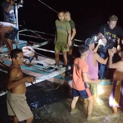In this image provided by the Philippine Coast Guard, a survivor is assisted as he alights from a small boat after being rescued from a burning ferry off Palawan province, Philippines on Wednesday Sept. 9, 2026. (Philippine Coast Guard via AP)