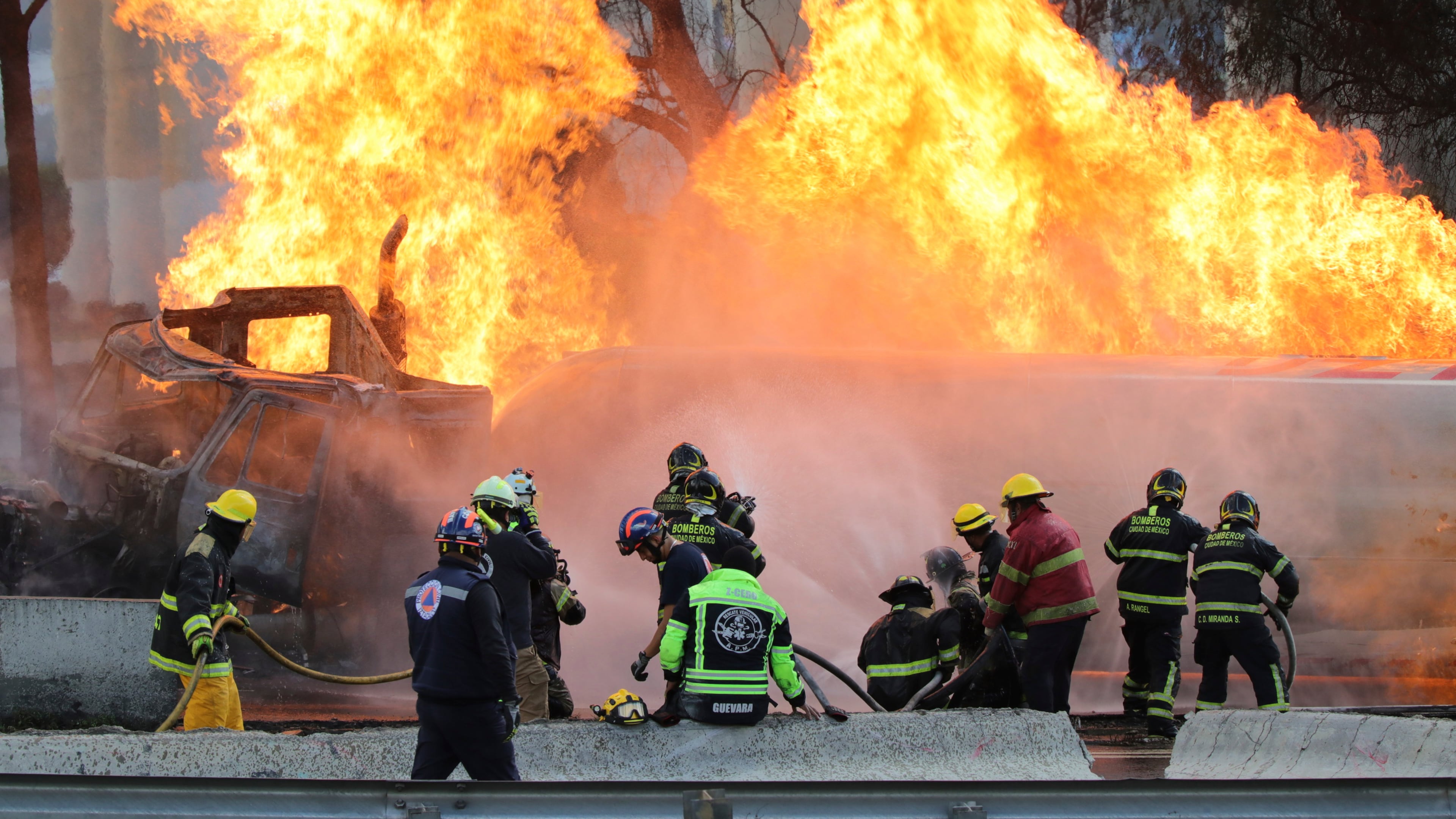 Firefighters spray hoses at a gas tanker that exploded under a highway overpass in Mexico City, Wednesday, Sept. 10, 2025. (AP Photo/Tristan Velazquez)