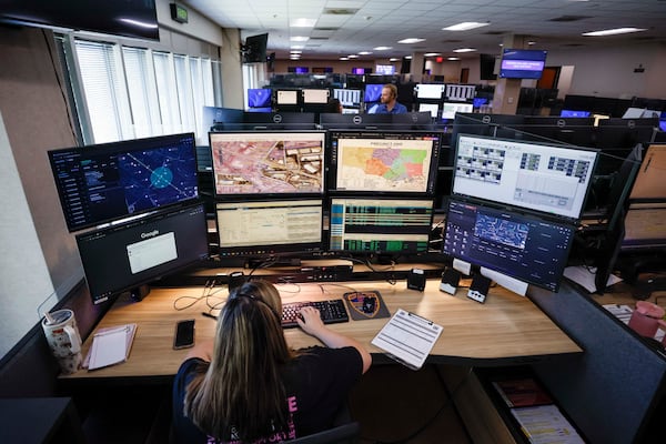 Emergency communications officer Julianna Shetterly operates eight screens during her shift in October 2025. (Miguel Martinez/AJC)